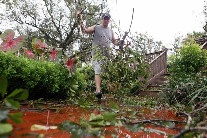 Danny Coughlin picks up branches from his backyard in the Lakeview neighborhood after Hurricane Isaac passed through in New Orleans, Louisiana August 30, 2012. REUTERS/Sean Gardner (UNITED STATES - Tags: ENVIRONMENT DISASTER) Published: Srp. 30, 2012, 9:30 odp.