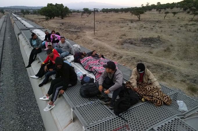 Migranti, většinou z Venezuely, odpočívají na střeše železničních vagónů, když se chystají pokračovat v cestě na hranice USA v místě známém jako El Basurero.