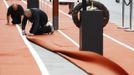 Workers lay a carpet designed like an athletics track at Westfield shopping centre near the Olympic Park at Stratford in London July 3, 2012. REUTERS/Luke MacGregor (BRITAIN - Tags: SPORT OLYMPICS BUSINESS) Published: Čec. 3, 2012, 5:06 odp.