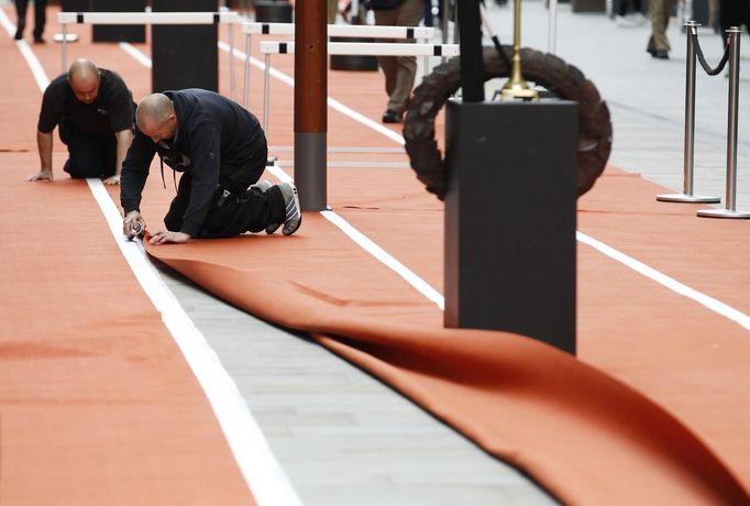 Workers lay a carpet designed like an athletics track at Westfield shopping centre near the Olympic Park at Stratford in London July 3, 2012. REUTERS/Luke MacGregor (BRITAIN - Tags: SPORT OLYMPICS BUSINESS) Published: Čec. 3, 2012, 5:06 odp.