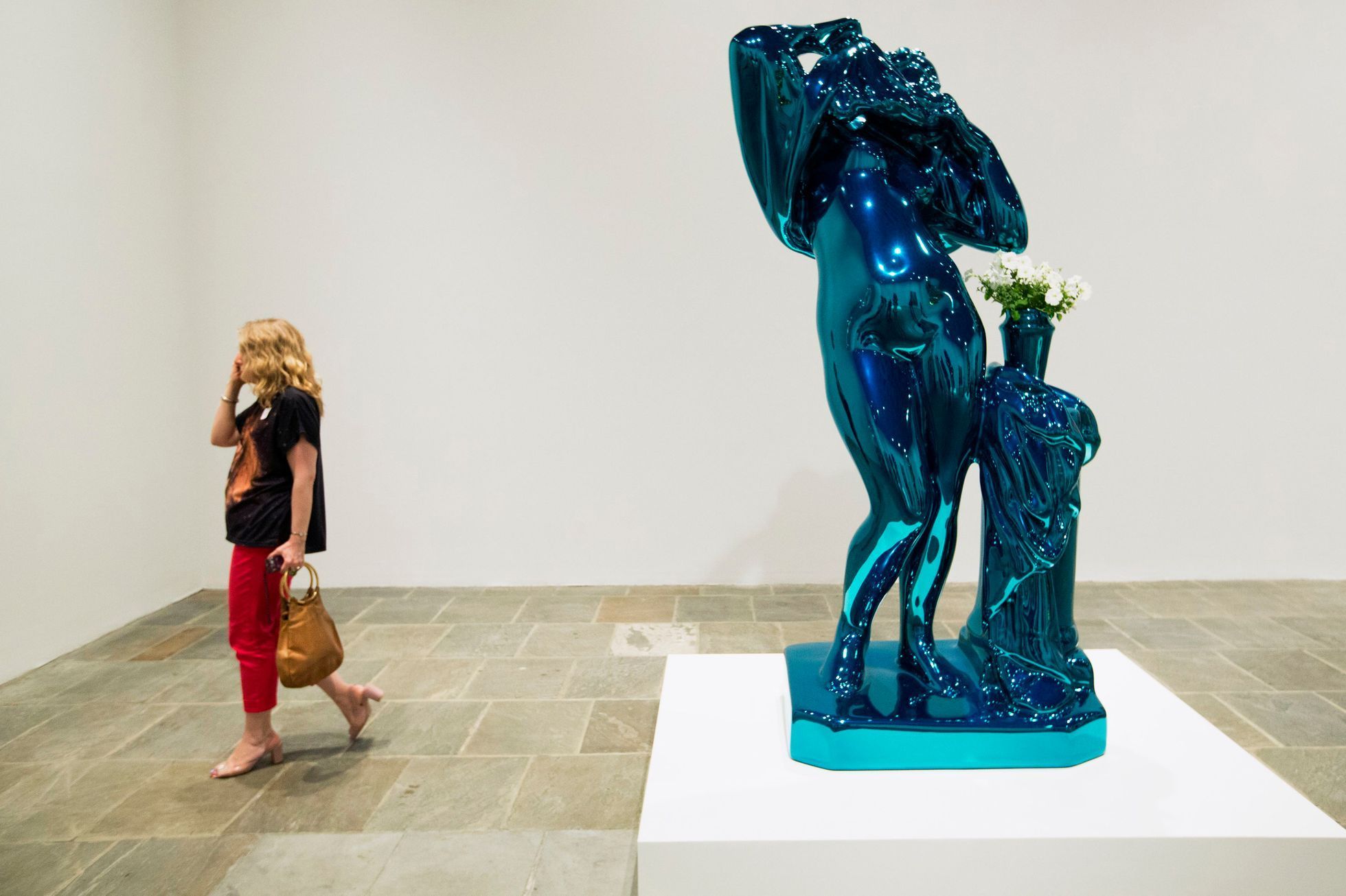 A woman walks past a sculpture before the opening of a Jeff Koons retrospective at the Whitney Museum of American Art in New York