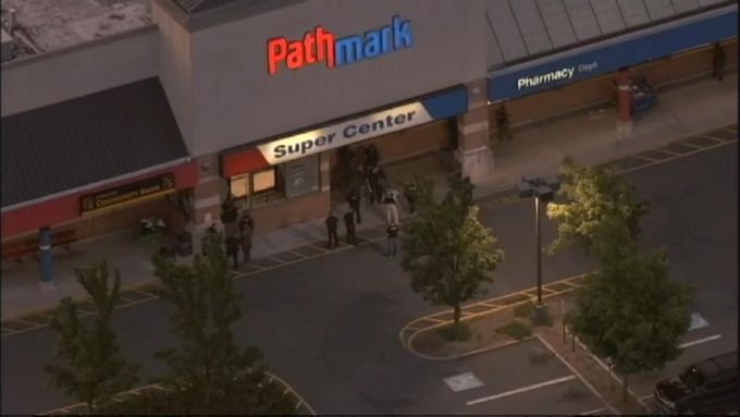 Policie odvádí lidi ze supermarketu, v němž se střílelo.
