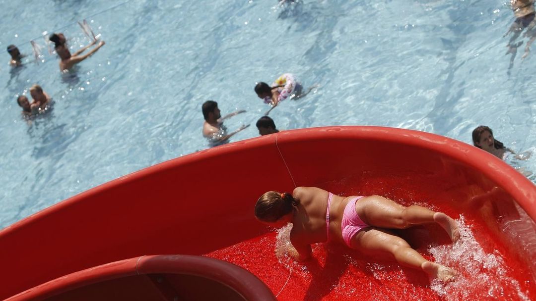 A youth slides down a water slide at the public swimming pool Kongressbad in Vienna June 30, 2012. Temperatures will rise up to 37 degrees Celsius (98.6 Fahrenheit) in Austria the next days, Austria's national weather service agency ZAMG reported. REUTERS/Lisi Niesner (AUSTRIA - Tags: ENVIRONMENT) Published: Čer. 30, 2012, 3 odp.