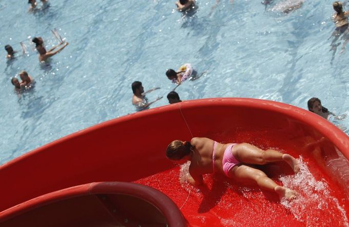 A youth slides down a water slide at the public swimming pool Kongressbad in Vienna June 30, 2012. Temperatures will rise up to 37 degrees Celsius (98.6 Fahrenheit) in Austria the next days, Austria's national weather service agency ZAMG reported. REUTERS/Lisi Niesner (AUSTRIA - Tags: ENVIRONMENT) Published: Čer. 30, 2012, 3 odp.