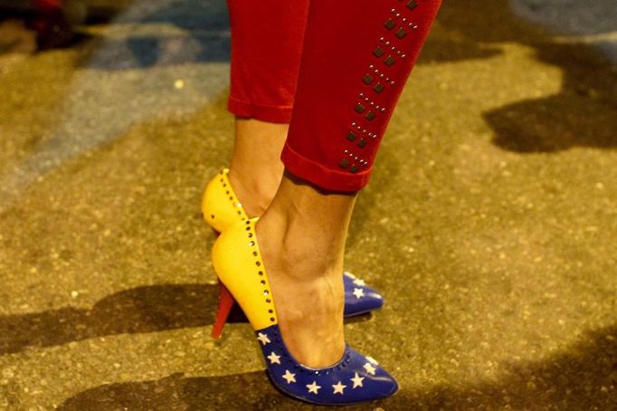 A supporter of Venezuelan president Hugo Chavez is pictured with footwear of the colours of the flag of Venezuela, outside Miraflores Palace while awaiting for the results of the Presidential elections in Caracas October 7, 2012. Venezuelans voted on Sunday with President Hugo Chavez facing the biggest electoral challenge yet to his socialist rule from a young rival tapping into discontent over crime and cronyism. REUTERS/Edwin Montilva (VENEZUELA - Tags: POLITICS ELECTION) Published: Říj. 8, 2012, 1:43 dop.