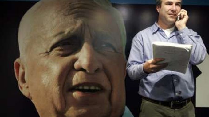 Novinář postává před obřím plakátem propagujícím stranu Kadima v Tel Avivu. Volby se konají na konci března.