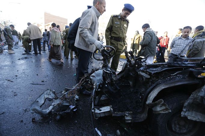 Policejní vyšetřovatelé v jemenském Saná obhlížejí místo, kde vybuchlo auto s výbušninami.