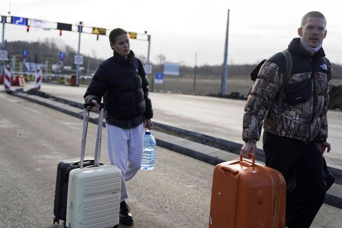 Lidé překračují hranici z Ukrajiny do Polska.