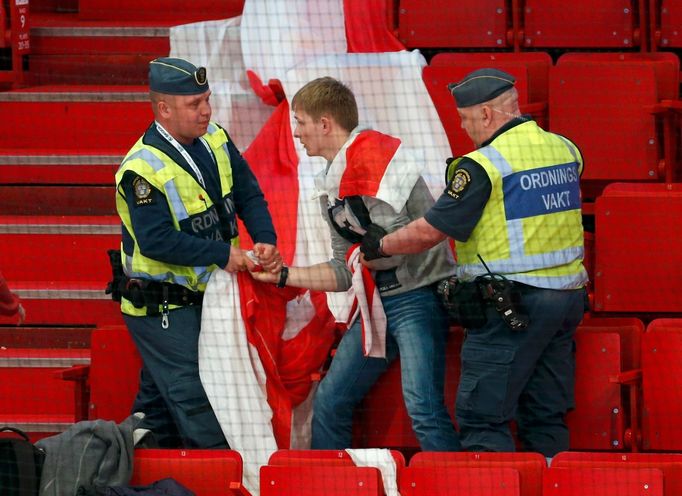 Pořadatelé ve Stockholmu vyvádějí fanouška se starou vlajkou Běloruska, zakázanou nedemokratickým režimem prezidenta Alexandra Lukašenka.