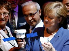 Kancléřka Angela Merkelová s modelem satelitu.