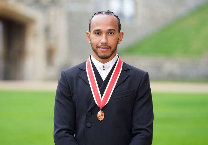 Lewis Hamilton poté, co byl britským princem Charlesem pasován na rytíře.