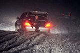 Muž naviguje řidiče při couvání na sněhem totálně zapadané dálnici poblíž makedonské Skopje.