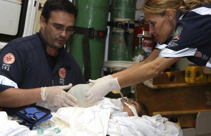 A woman, who was wounded during a fire at Boate Kiss nightclub, is transferred from a hospital in Santa Maria to receive treatment at Porto Alegre hospital in the southern city of Santa Maria, 187 miles (301 km) west of the state capital Porto Alegre early January 28, 2013. The nightclub fire killed at least 232 people in Santa Maria early on Sunday when a band's pyrotechnics show set the building ablaze and fleeing partygoers stampeded toward blocked and overcrowded exits in the ensuing panic, officials said. REUTERS/Ricardo Moraes (BRAZIL - Tags: DISASTER HEALTH) Published: Led. 28, 2013, 5:02 dop.