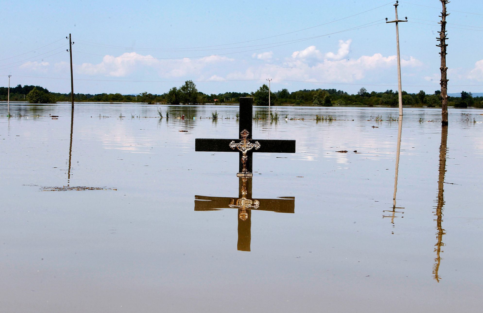 Jenom kříž je vidět v zaplavené části vesnice Vojskova.