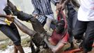 ATTENTION EDITORS - VISUAL COVERAGE OF SCENES OF INJURY OR DEATH A victim is carried from the scene of a plane crash in Nigeria's commercial capital Lagos, June 3, 2012. A passenger plane carrying nearly 150 people crashed into a densely populated part of Lagos on Sunday, in what looked like a major disaster in Nigeria's commercial hub. There was no early word from airline or civil aviation authority officials in the West African country on casualties. REUTERS/Stringer (NIGERIA - Tags: DISASTER TRANSPORT) QUALITY FROM SOURCE TEMPLATE OUT Published: Čer. 3, 2012, 6:45 odp.