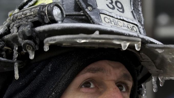 Firefighter Michael De Jesus is covered in ice as he mans a water cannon while fighting a warehouse fire in Chicago January 24, 2013, which caught fire Tuesday night. Fir