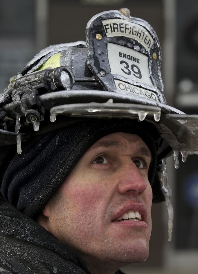 Firefighter Michael De Jesus is covered in ice as he mans a water cannon while fighting a warehouse fire in Chicago January 24, 2013, which caught fire Tuesday night. Fire department officials said it is the biggest fire the department has had to battle in years and one-third of all Chicago firefighters were on the scene at one point or another trying to put out the flames. REUTERS/John Gress (UNITED STATES - Tags: DISASTER ENVIRONMENT) Published: Led. 24, 2013, 9:48 odp.