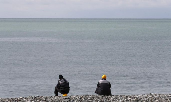 Construction workers enjoy their lunch break at the seafront next to the Olympic stadium for the Sochi 2014 Winter Olympics in Adler, near Sochi February 18, 2013. Although many complexes and venues in the Black Sea resort of Sochi mostly resemble building sites that are still under construction, there is nothing to suggest any concern over readiness. Construction will be completed by August 2013 according to organizers. The Sochi 2014 Winter Olympics opens on February 7, 2014. REUTERS/Kai Pfaffenbach (RUSSIA - Tags: BUSINESS CONSTRUCTION ENVIRONMENT SPORT OLYMPICS) Published: Úno. 18, 2013, 6:36 odp.