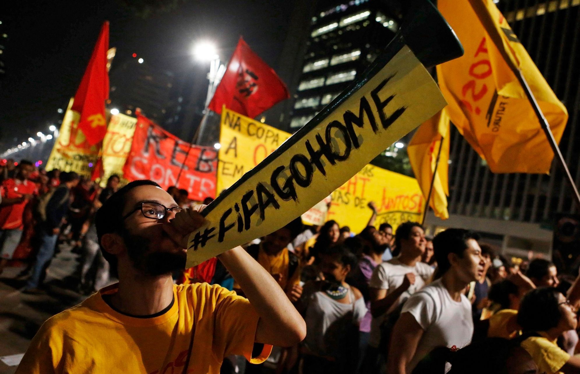 A demonstrator blows a horn during a protest against the 2014 World Cup, in Sao Paulo