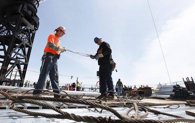 Iron workers Steven Cross (L) and Adam Cross prepare steel cables to lift iron beams on the 100th story of One World Trade Center in New York, April 30, 2012. The addition of iron columns to the 100th story pushed the height of One World Trade above that of the Empire State Building today. REUTERS/Lucas Jackson (UNITED STATES - Tags: CITYSPACE SOCIETY BUSINESS CONSTRUCTION) Published: Dub. 30, 2012, 11:47 odp.