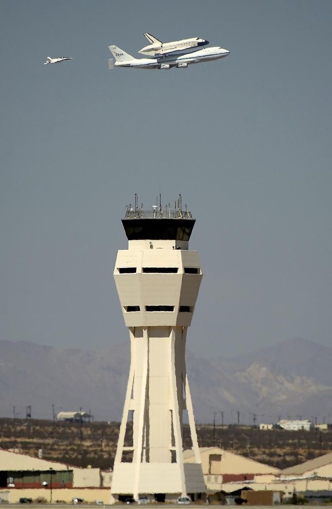 The space shuttle Endeavour, carried piggyback atop a Boeing 747 jumbo jet, makes a flyby before landing at Edwards Air Force Base in California, September 20, 2012, after a cross-country trip to Los Angeles to begin its final mission as a museum exhibit. Endeavour is scheduled to take off for its final ferry flight again on Friday, and the final airborne journey of the entire space shuttle fleet, headed for Los Angeles International Airport. REUTERS/Gene Blevins (UNITED STATES - Tags: TRANSPORT SCIENCE TECHNOLOGY) Published: Zář. 20, 2012, 10:19 odp.