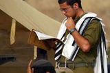 Izraelští vojáci rozmístění na hranicích s Libanonem se ráno modlí.