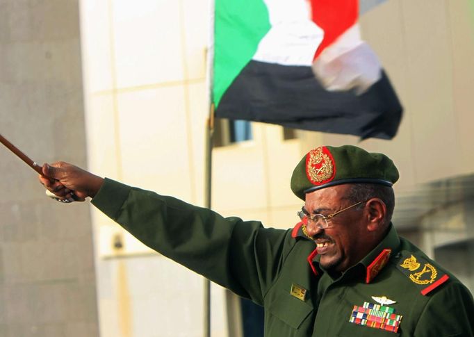 Sudanese President Omar Hassan al-Bashir waves to supporters after receiving victory greetings at the Defence Ministry, in Khartoum