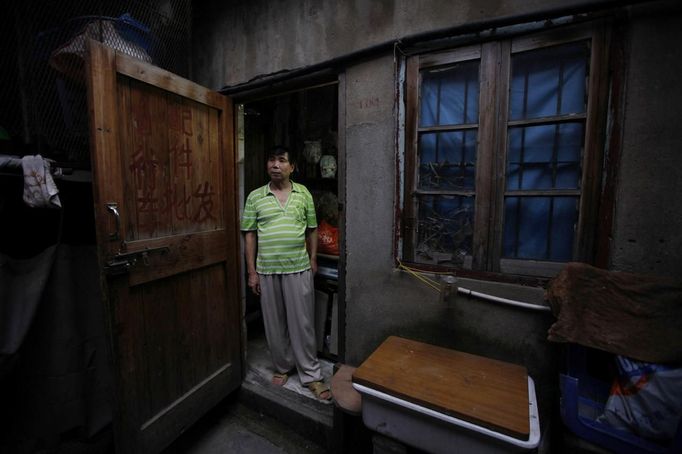 Xiao Cao, a 57-year-old gay man, stands in the doorway of his eight-square-metre apartment in Shanghai April 8, 2012. China's gay community has long been on the edges of society but it is gradually becoming more accepted. Cao, who is an unemployed drag queen, is one whose life lifts the curtain on a less romanticised view of Chinese homosexuals. Living in an eight-square-metre apartment behind a public toilet and with a monthly income of 500 yuan ($79) from social insurance, he passes his days dancing in public and spending time with friends at gay clubs. Picture taken April 8, 2012. REUTERS/Aly Song (CHINA - Tags: SOCIETY) CHINA OUT. NO COMMERCIAL OR EDITORIAL SALES IN CHINA. ATTENTION EDITORS PICTURE 01 OF 28 OF PACKAGE 'GAY AND OUT IN CHINA' TO FIND ALL IMAGES SEARCH 'GAY OUT CHINA' Published: Čer. 1, 2012, 12:32 dop.