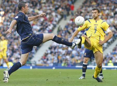 David Weir se snaží zastavit andreje Ševčenka v kvalifikačním duelu Ukrajiny se Skotskem.