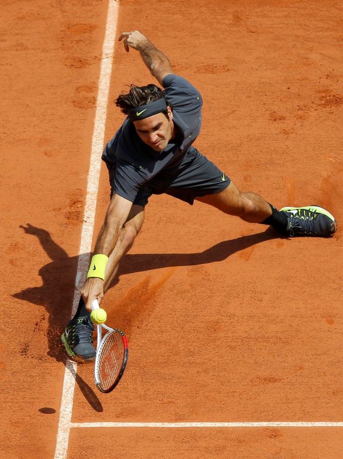 Švýcarský tenista Roger Federer se natahuje po míčku v utkání s Rumunem Adrianem Ungurem ve 2. kole French Open 2012.