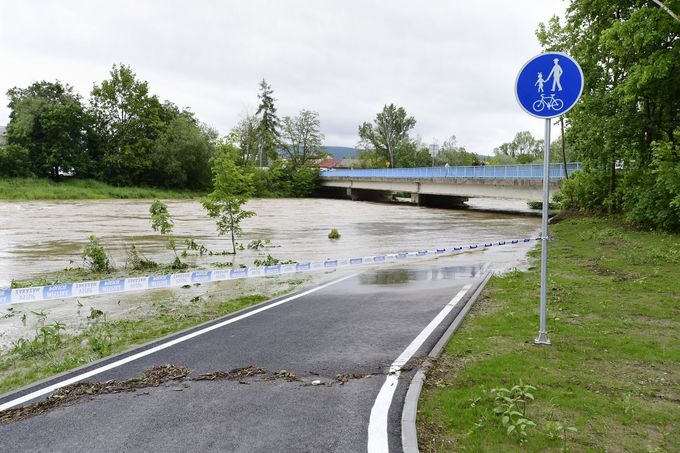 Páska zakazující vstup na stezku u břehu řeky Bečvy, jejíž hladinu zvedl vytrvalý déšť, na snímku z 23. května 2019 v Lipníku nad Bečvou.
