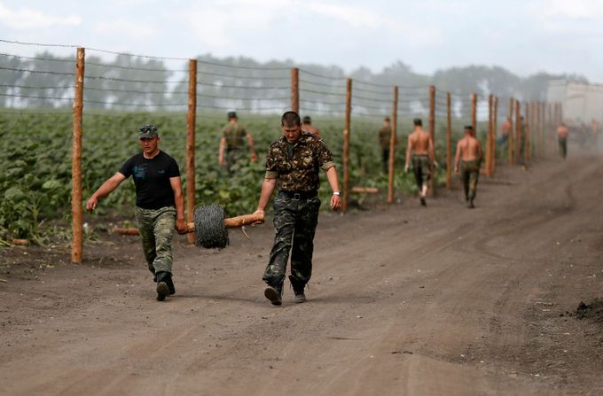 Ukrajinští vojáci staví plot z ostnatého drátu u vojenské základny poblíž Slavjansku.