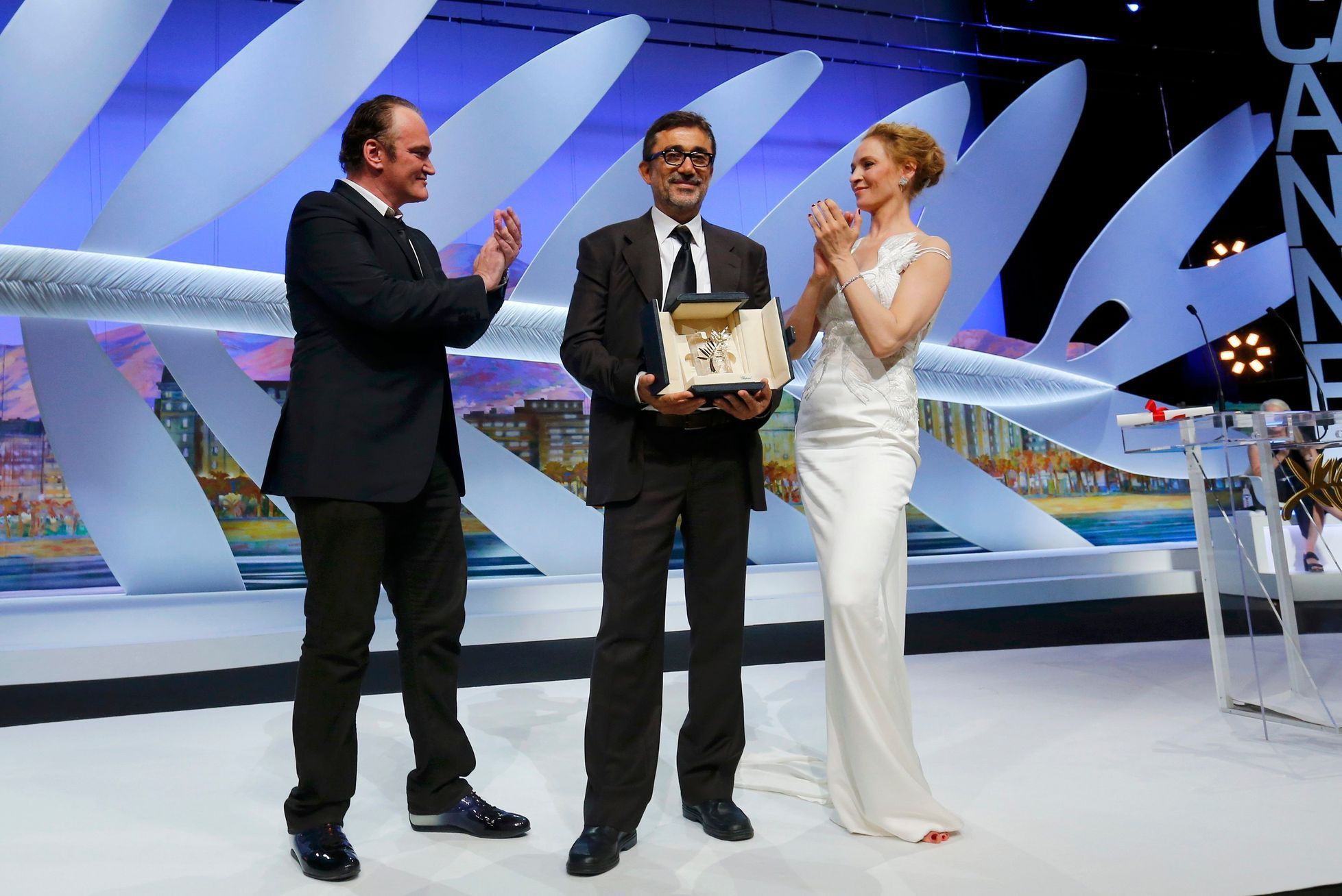 Director Nuri Bilge Ceylan, Palme d'Or award winner for his film &quot;Winter Sleep&quot;, poses on stage surrounded by director Quentin Tarantino and actress Uma Thurman during the closing ceremony o