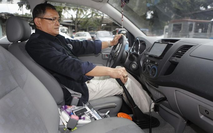 Jaime "Jimmy" Santiago, a lower court judge in Manila, keeps his service pistol beside him while he onboard on his vehicle after a shooting practice wit his fellow court judges at a police firing range in Manila March 6, 2013. Santiago, a former police officer who headed a special weapons and tactics (SWAT) unit, favours arming Filipino judges to protect themselves from disgruntled litigants who can't accept decisions and criminal syndicates whose members were sent to jail. There had been cases of shootings inside courtrooms. Picture taken March 6, 2013. REUTERS/Romeo Ranoco (PHILIPPINES - Tags: POLITICS CRIME LAW) Published: Dub. 4, 2013, 11:24 dop.