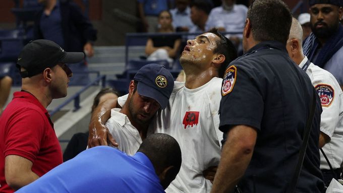 Záchranáři poskytují první pomoc muži, který během zápasu zkolaboval