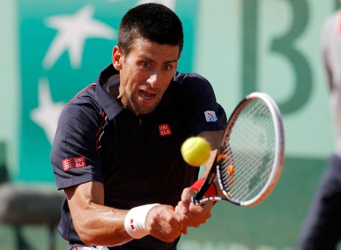 Srbský tenista Novak Djokovič vrací míček Švýcaru Rogeru Federerovi během semifinále French Open 2012.