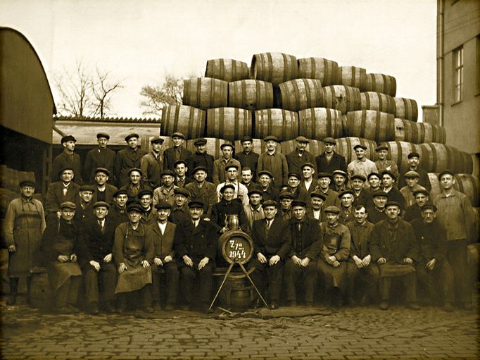 Pracovníci bednářské dílny pivovaru ve válečném roce 1944. Bojují s nedostatkem prostoru na dolejším dvoře, sudy vyrovnané do velkých pyramid jsou všude.