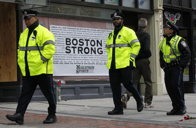 Police officers walk past the site of the first explosion on Boylston Street after the street reopened to the public for the first time since the Boston Marathon bombings in Boston, Massachusetts April 24, 2013. REUTERS/Jessica Rinaldi (UNITED STATES - Tags: CRIME LAW CIVIL UNREST) Published: Dub. 24, 2013, 12:36 odp.