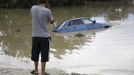 A local resident looks at a submerged car in a flooded street in the village of Novoukrainsk, near the southern Russian town of Krymsk, July 7, 2012. At least 99 people were killed in floods and landslides in southern Russia after two months' average rainfall fell in a few hours overnight, police and emergency officials said on Saturday. REUTERS/Vladimir Anosov (RUSSIA - Tags: DISASTER ENVIRONMENT TPX IMAGES OF THE DAY) Published: Čec. 7, 2012, 3:30 odp.