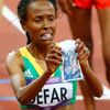Etiopská dálková běžkyně Meseret Defarová ukazuje kousek látky s náboženskou ikonou po vítězství v běhu na 5000 metrů na OH 2012 v Londýně.