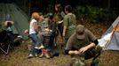 Members of the North Florida Survival Group, including leader Jim Foster (2L) relax in their camp as they take a short break from performing land navigation and enemy contact drills during a field training exercise in Old Town, Florida, December 8, 2012. The group trains children and adults alike to handle weapons and survive in the wild. The group passionately supports the right of U.S. citizens to bear arms and its website states that it aims to teach "patriots to survive in order to protect and defend our Constitution against all enemy threats". Picture taken December 8, 2013. REUTERS/Brian Blanco (UNITED STATES - Tags: SOCIETY POLITICS) ATTENTION EDITORS: PICTURE 17 OF 20 FOR PACKAGE 'TRAINING CHILD SURVIVALISTS' SEARCH 'FLORIDA SURVIVAL' FOR ALL IMAGES Published: Úno. 22, 2013, 1:01 odp.