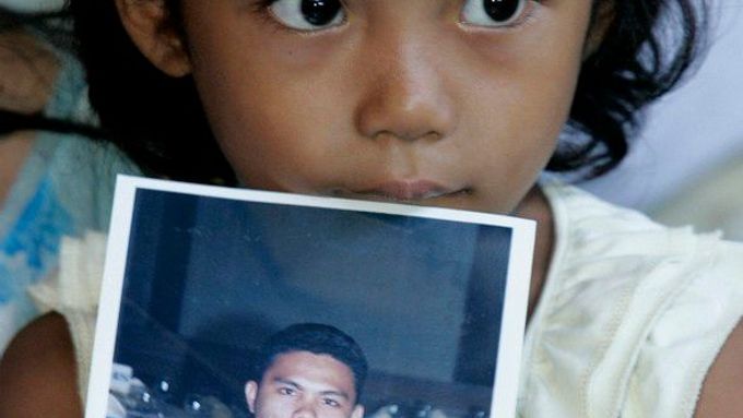 Čtyřletá Angel Kate Laurentová drží fotografii svého otce Jomera, který patřil k posádce potopené lodi. Nyní je mezi více než sedmi sty lidmi, kteří jsou stále nezvěstní.
