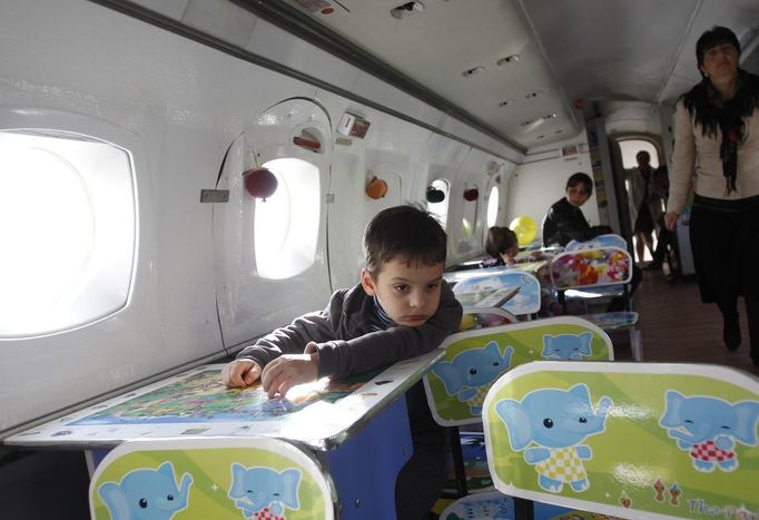 Children play in the cabin of a plane at a kindergarten in the town of Rustavi some 25 km (15 miles) south of Tbilisi, October 31, 2012. The fully functional Soviet-era Yakovlev Yak-40 plane has been installed in the kindergarten courtyard and refurbished as a children's playground. REUTERS/David Mdzinarishvili (GEORGIA - Tags: EDUCATION SOCIETY) Published: Říj. 31, 2012, 11:19 dop.