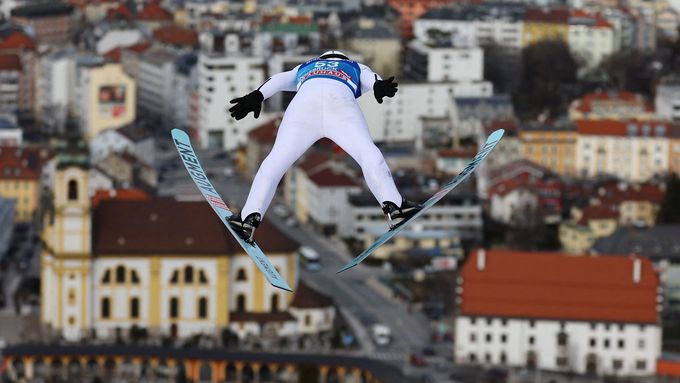 Rakušan Manuel Fettner letí při letošním Turné čtyř můstků ku sněhuprostým ulicím Innsbrucku