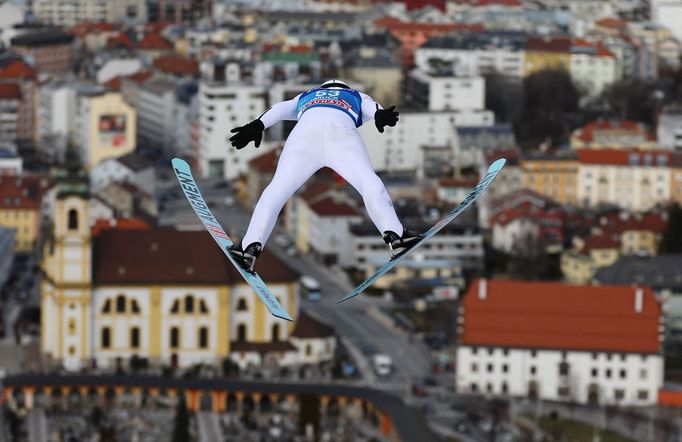 Rakušan Manuel Fettner letí při letošním Turné čtyř můstků ku sněhuprostým ulicím Innsbrucku