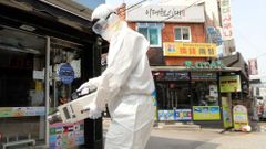 Dezinfekzce obchodů a restaurací v soulské čtvrti Itaewon, kde se o víkendu znovu rozšířil koronavirus.