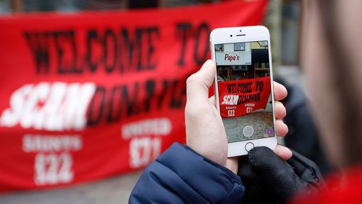 Manchester United fans take photographs of a protest banner in the town centre before the match