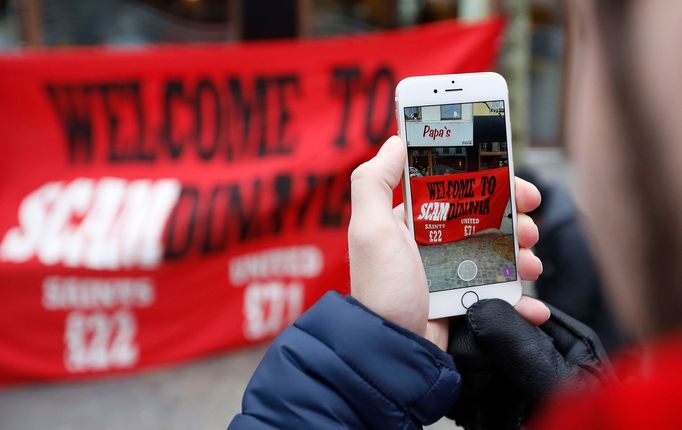 Manchester United fans take photographs of a protest banner in the town centre before the match