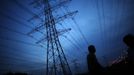 A farmer stands under high voltage power lines at a suburban area of Shanghai in this August 19, 2012 file photo. China relocated 1.3 million people during the 17 years it took to complete the Three Gorges dam. Even after finishing the $59 billion project last month, the threat of landslides along the dam's banks will force tens of thousands to move again. It's a reminder of the social and environmental challenges that have dogged the world's largest hydroelectric project. While there has been little protest among residents who will be relocated a second time, the environmental fallout over other big investments in China has become a hot-button issue ahead of a leadership transition this year. Picture taken August 19, 2012. To match story CHINA-THREEGORGES/ REUTERS/Carlos Barria/Files (CHINA - Tags: POLITICS ENVIRONMENT BUSINESS ENERGY) Published: Srp. 22, 2012, 8:41 odp.