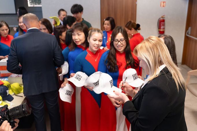 Vietnamky přivítaly politiky v tradičních krojích, ovšem s motivy vietnamské a české vlajky.